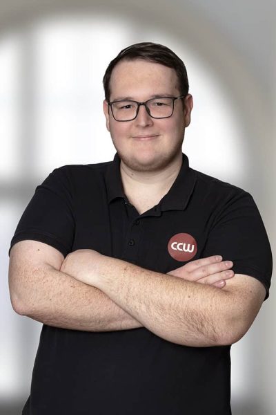 Mitarbeiter von CCW ICT-Services mit Brille und schwarzen Polo-Shirt.